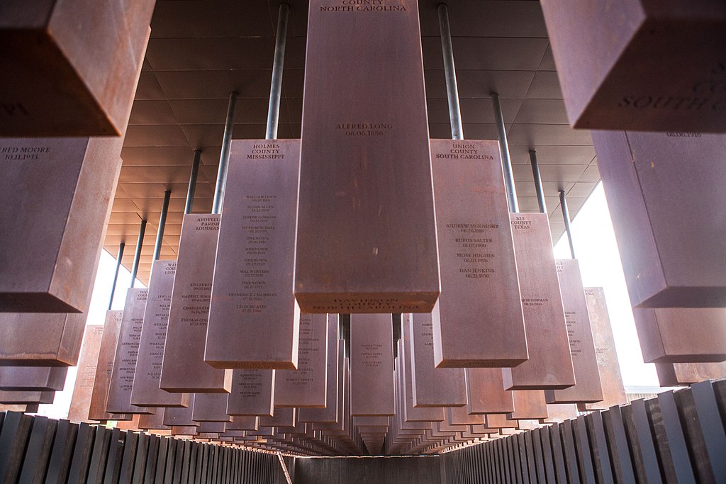 Hanging metal slabs inscribed with the names of towns and dates on which lynchings occurred
