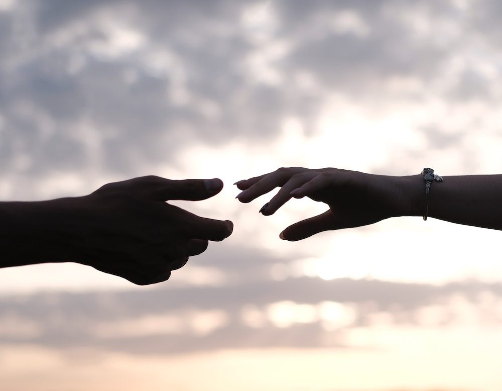 Two hands reaching for each other